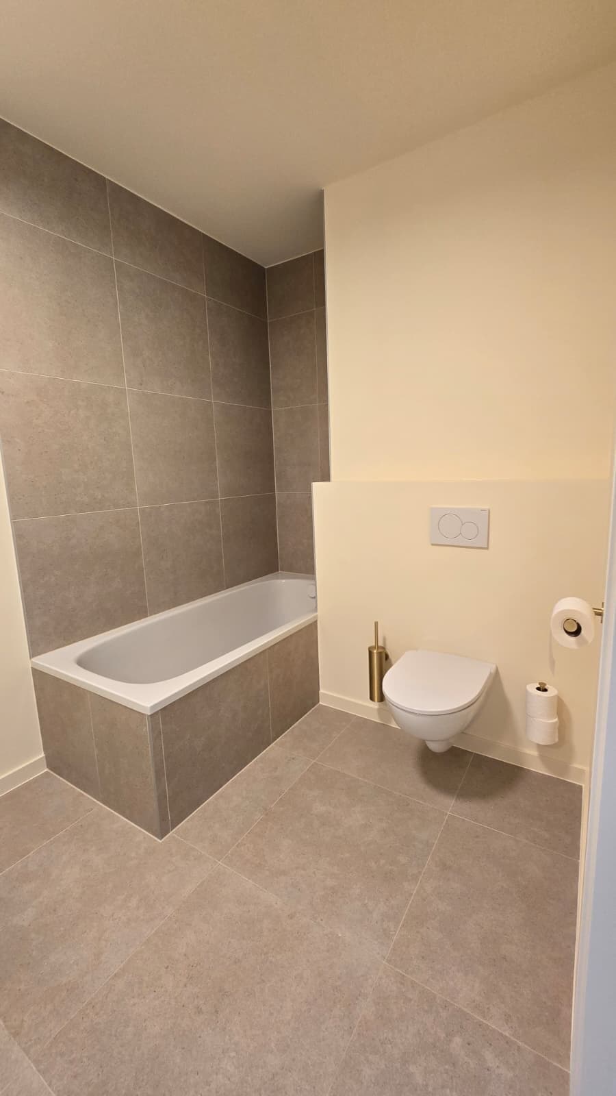 Badkamer met ligbad en hangtoilet